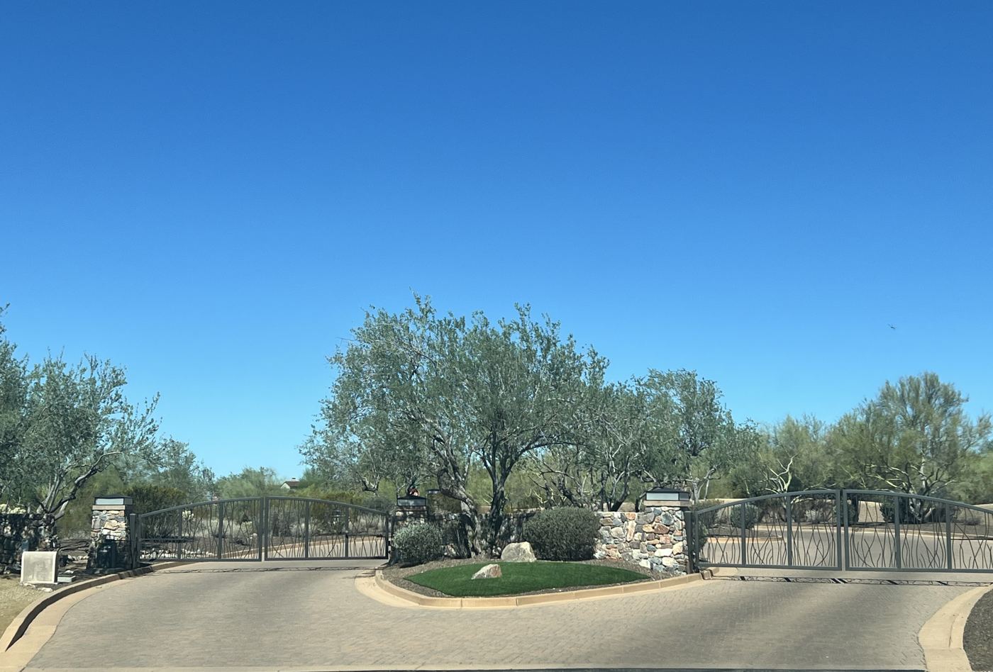 The gated entrance to a North Scottsdale community, lined with desert trees