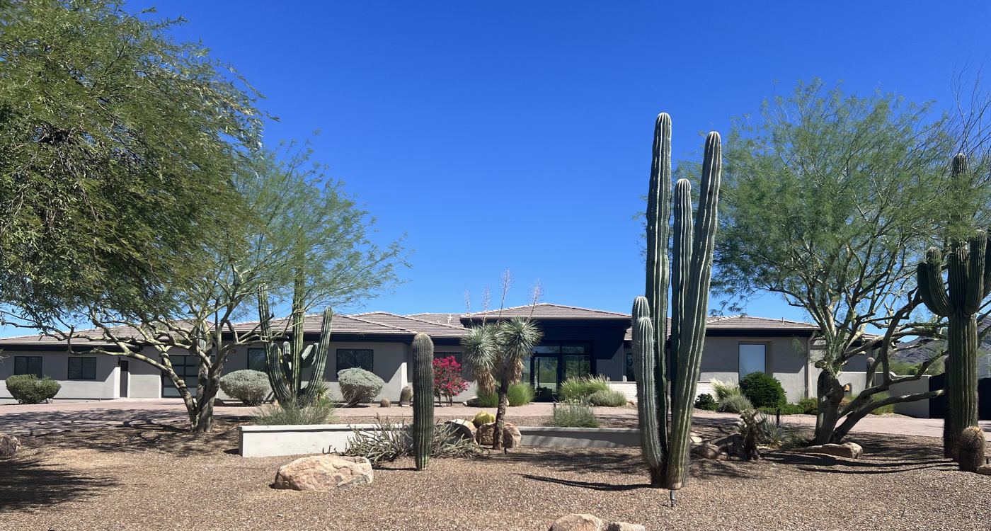 A modern single-story home with saguaro and desert landscaping